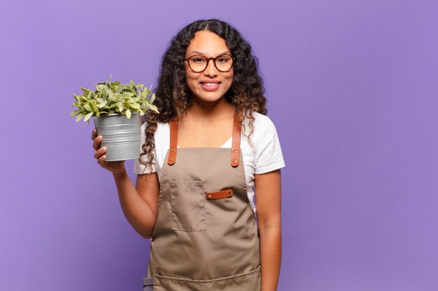 Joven hispana que parece feliz y gratamente sorprendida, emocionada con una expresión fascinada y conmocionada. concepto de cuidador de jardín