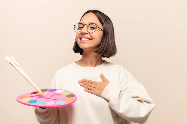 Foto joven hispana que parece feliz, segura y digna de confianza, sonriendo y mostrando el signo de la victoria, con una actitud positiva