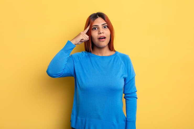 Foto joven hispana que parece sorprendida, con la boca abierta, conmocionada, al darse cuenta de un nuevo pensamiento, idea o concepto