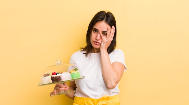 Joven hispana que se siente aburrida, frustrada y somnolienta después de un aburrido concepto de pasteles caseros