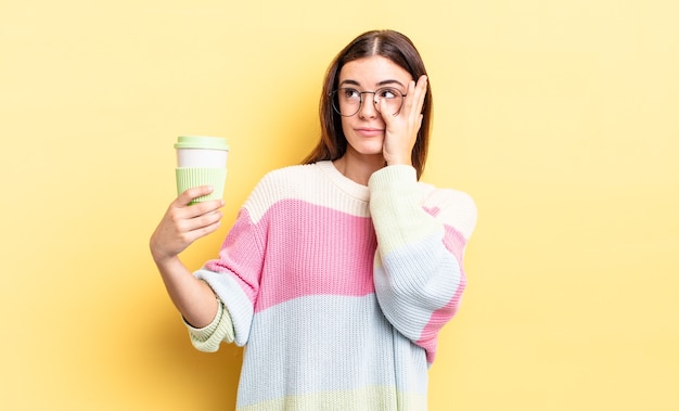 Joven hispana que se siente aburrida, frustrada y con sueño después de un cansancio. concepto de café para llevar