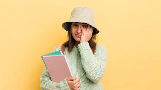 Joven hispana que se siente aburrida, frustrada y con sueño después de un concepto de estudiante aburrido