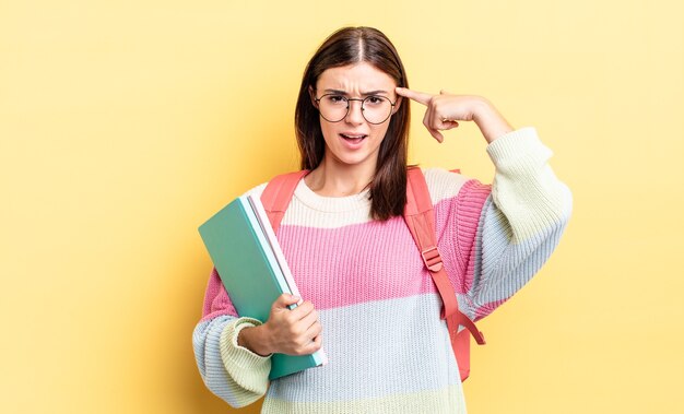 Joven hispana que se siente confundida y perpleja, mostrando que estás loco. concepto de estudiante