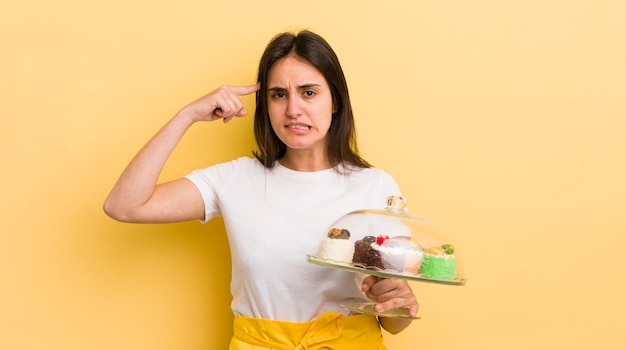 Foto joven hispana que se siente confundida y perpleja mostrando que estás loco por el concepto de pasteles caseros