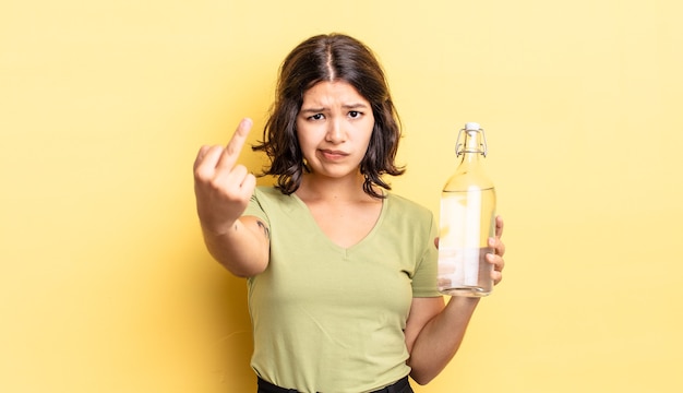 Joven hispana que se siente enojada, molesta, rebelde y agresiva. concepto de botella de agua