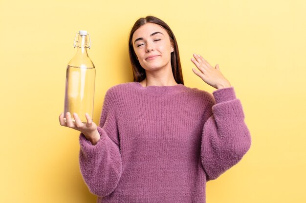 Joven hispana que se siente estresada, ansiosa, cansada y frustrada. concepto de botella de agua