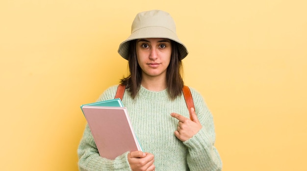 Joven hispana que se siente feliz y se señala a sí misma con un concepto de estudiante emocionado