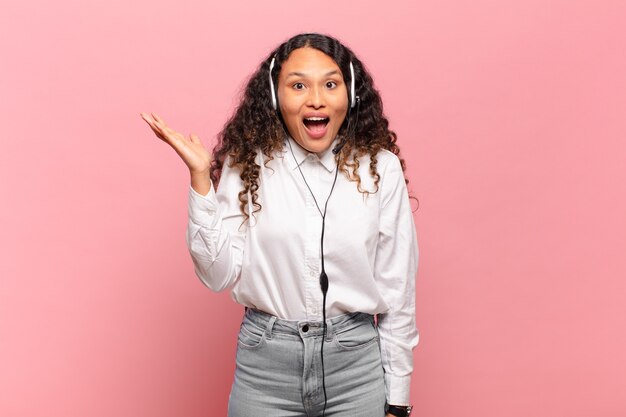 Joven hispana que se siente feliz, sorprendida y alegre, sonriendo con actitud positiva, dándose cuenta de una solución o idea