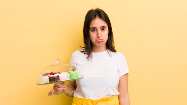 Joven hispana que se siente triste y quejumbrosa con una mirada infeliz y llorando concepto de pasteles caseros