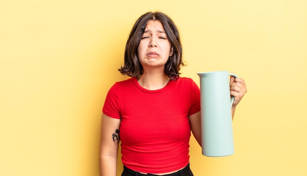 Joven hispana que se siente triste y quejumbrosa con una mirada infeliz y llorando. concepto de termo