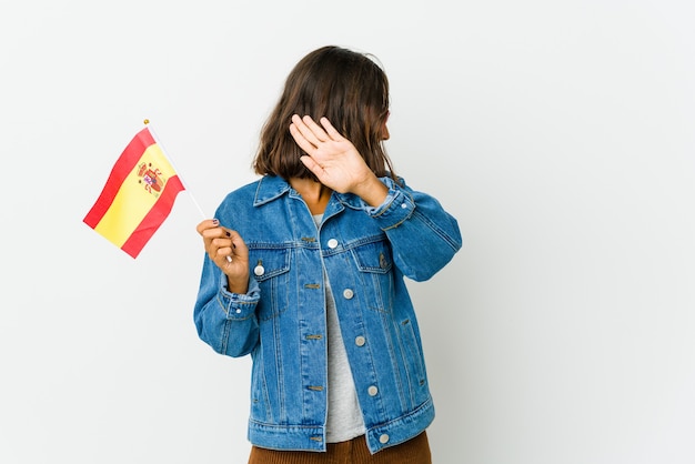 Joven hispana de raza mixta sosteniendo una bandera española