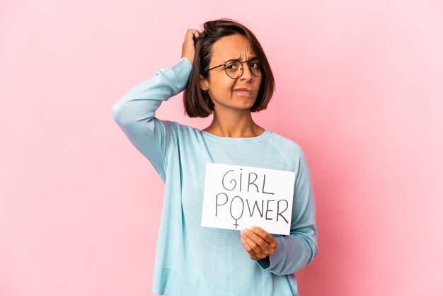 Foto joven hispana de raza mixta sosteniendo una pancarta de mensaje de poder femenino sorprendida, ella ha recordado una reunión importante.