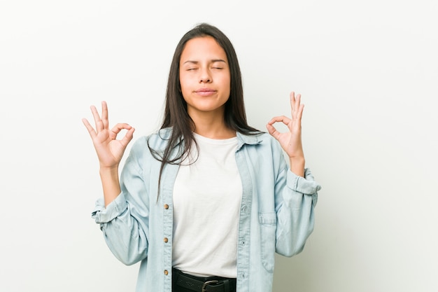 Joven hispana se relaja después de un duro día de trabajo, está realizando yoga.