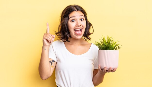 Joven hispana sintiéndose como un genio feliz y emocionado después de darse cuenta de una idea. concepto de crecimiento