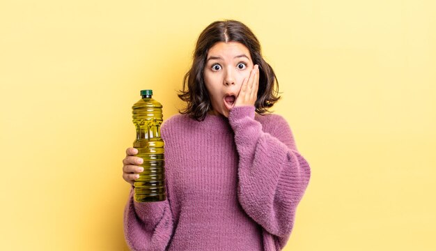 Joven hispana sintiéndose conmocionada y asustada. concepto de aceite de oliva