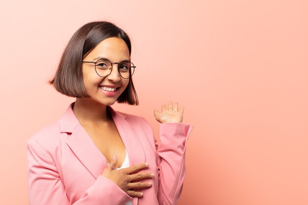 Joven hispana sintiéndose feliz y alegre, sonriendo y dándole la bienvenida