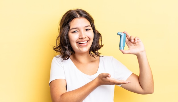 Joven hispana sonriendo alegremente, sintiéndose feliz y mostrando un concepto. concepto de asma