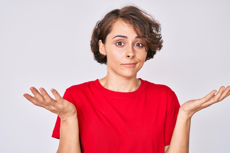 Foto joven hispana vestida con ropa informal sin idea y confundida con los brazos abiertos, sin idea y cara dudosa.