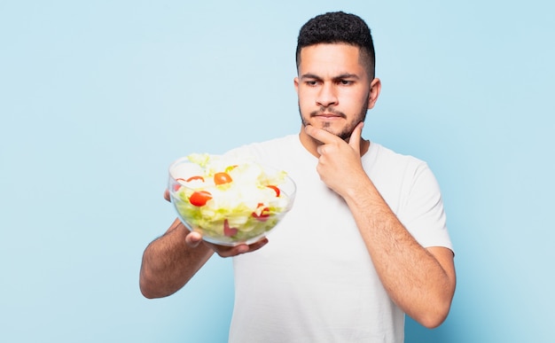 Joven hispano dudando o expresión incierta y concepto de dieta