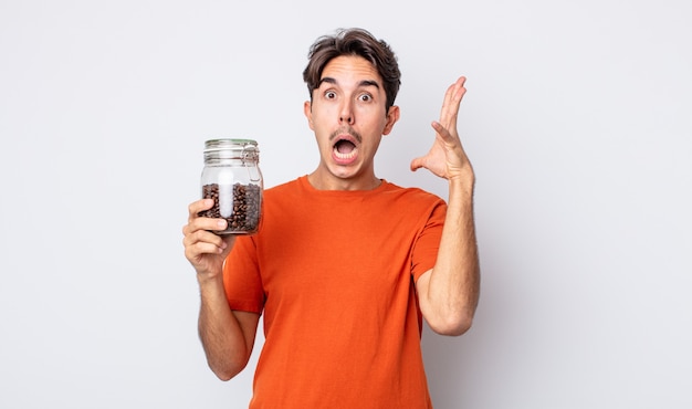 Joven hispano gritando con las manos en el aire. concepto de granos de cafe