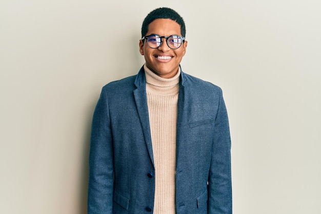 Joven hispano guapo con ropa elegante y gafas con una sonrisa alegre y fresca en la cara. persona con suerte.