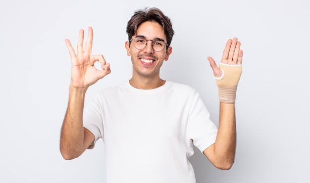 Joven hispano que se siente feliz, mostrando aprobación con un gesto bien. concepto de vendaje de mano