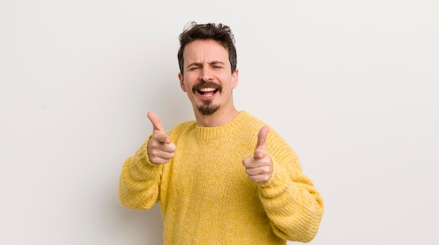 Un joven hispano se siente feliz, fresco, satisfecho, relajado y exitoso, apuntando a la cámara eligiéndote