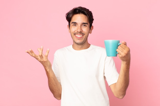 Joven hispano se siente feliz, sorprendido al darse cuenta de una solución o idea y sosteniendo una taza de café