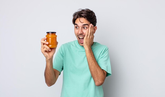 Joven hispano sintiéndose feliz emocionado y sorprendido concepto de gelatina de durazno