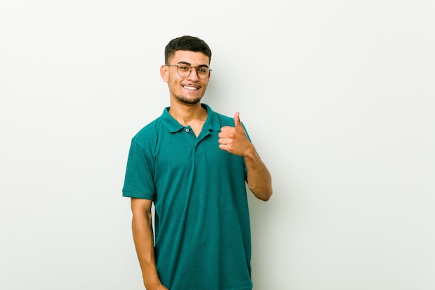 Joven hispano sonriendo y levantando el pulgar