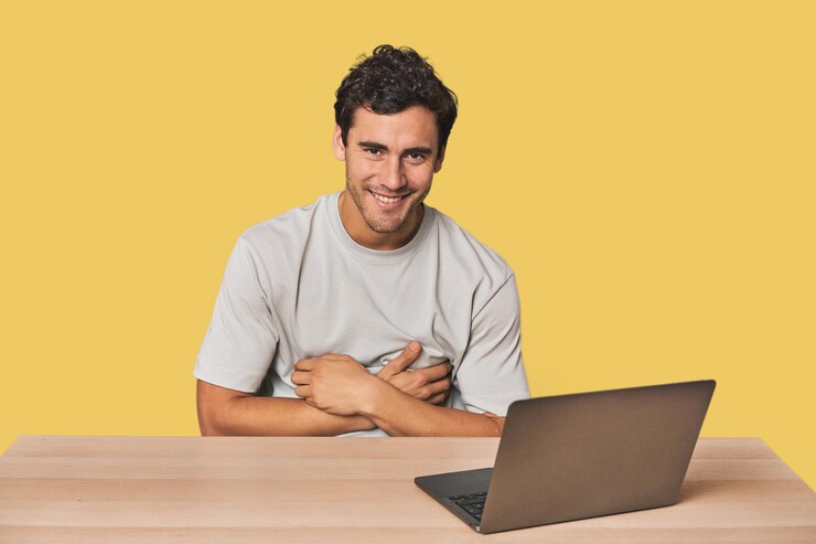 Foto joven hispano trabajando en una computadora portátil riendo y divirtiéndose