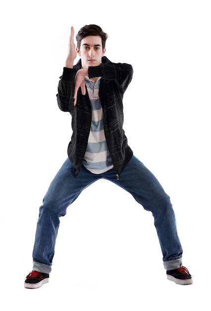 joven hombre adolescente bailando y saltando aislado sobre fondo blanco en el estudio