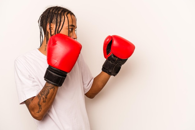 Joven hombre afroamericano jugando boxeo aislado sobre fondo blanco.