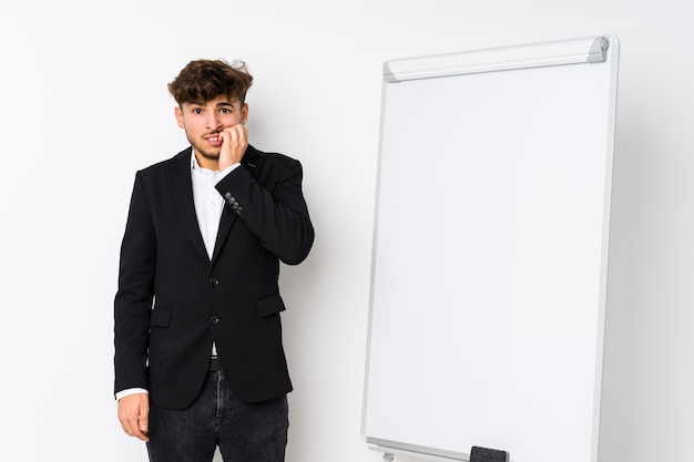 Joven hombre árabe de coaching empresarial mordiéndose las uñas, nervioso y muy ansioso.