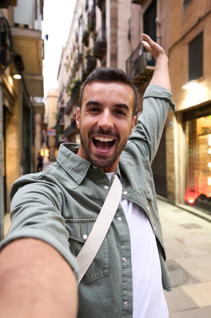 Joven hombre caucásico emocionado tomando una selfie en la calle turística de la ciudad de París en el fondo