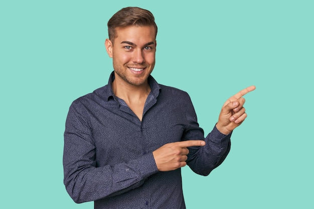 Foto joven hombre caucásico en el estudio emocionado señalando con los dedos índice