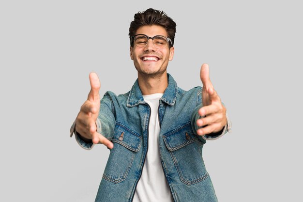 Joven hombre caucásico y guapo aislado mostrando una expresión de bienvenida