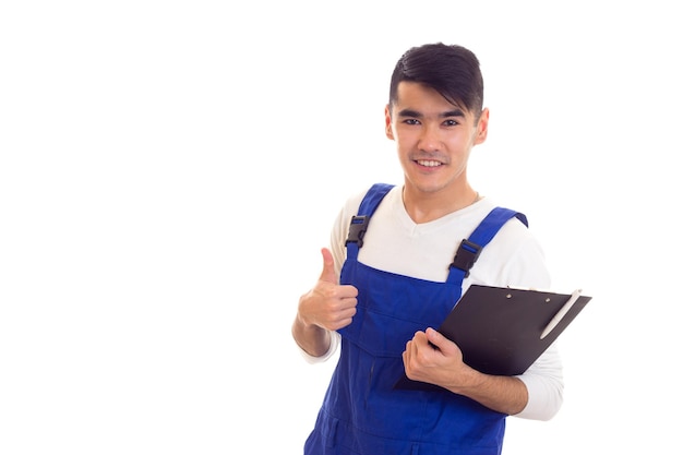 Joven hombre feliz con cabello oscuro vestido con camisa blanca y escritura general azul en una carpeta negra