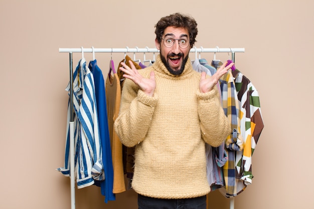 Joven hombre fresco con ropa contra la pared plana