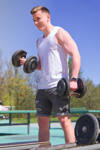 Joven hombre fuerte en forma entrenando al aire libre fitness concepto de estilo de vida saludable