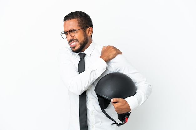 Joven hombre latino de negocios con un casco de motocicleta aislado de fondo blanco que sufre de dolor en el hombro por haber hecho un esfuerzo