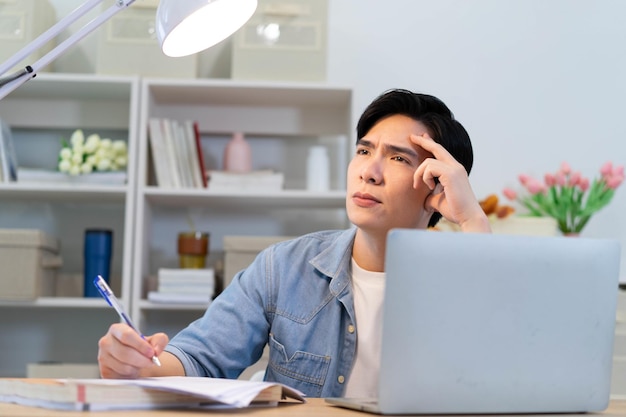 Joven hombre de negocios asiático trabajando en casa