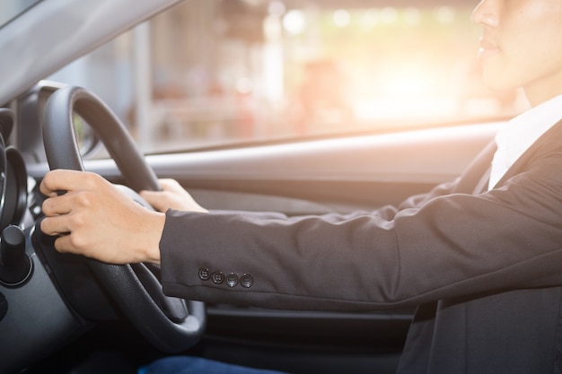 Joven, hombre de negocios, conducir un coche