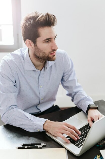 joven, hombre de negocios, trabajando, en, oficina, utilizar, computador portatil