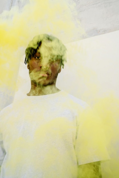 Foto joven hombre negro con un humo amarillo