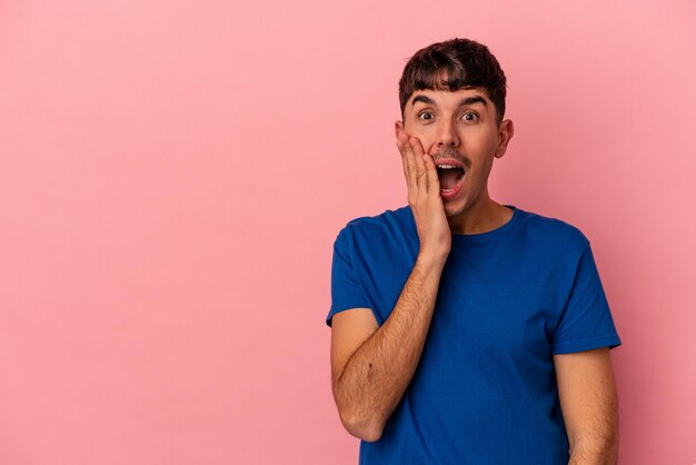 Foto joven hombre de raza mixta aislado en fondo rosa grita fuerte mantiene los ojos abiertos y las manos tensas