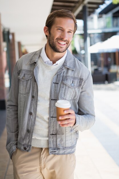 Joven hombre sonriente feliz sosteniendo una taza de café