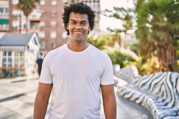 Joven hombre del sureste sonriendo confiado caminando en la calle