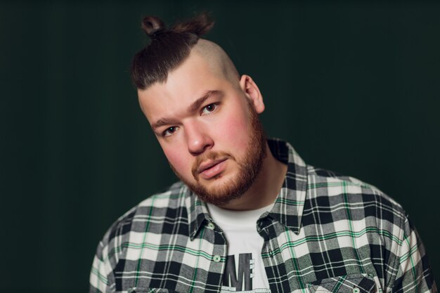 Joven inconformista guapo caucásico con barba posando en el estudio