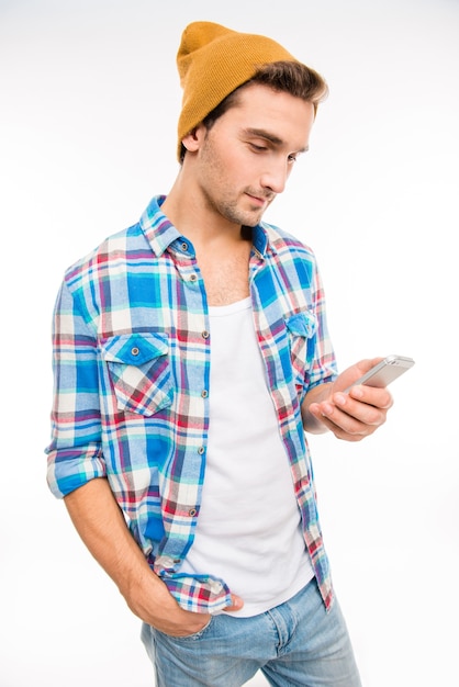 Joven inconformista con teléfono móvil con la mano en el bolsillo